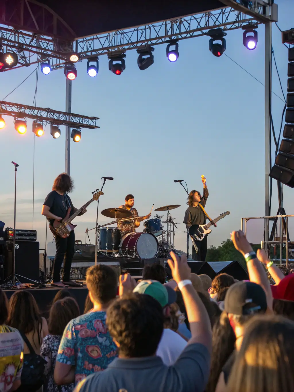 A dynamic image of a live band performing on an outdoor stage during a community music festival, with a diverse audience enjoying the performance.