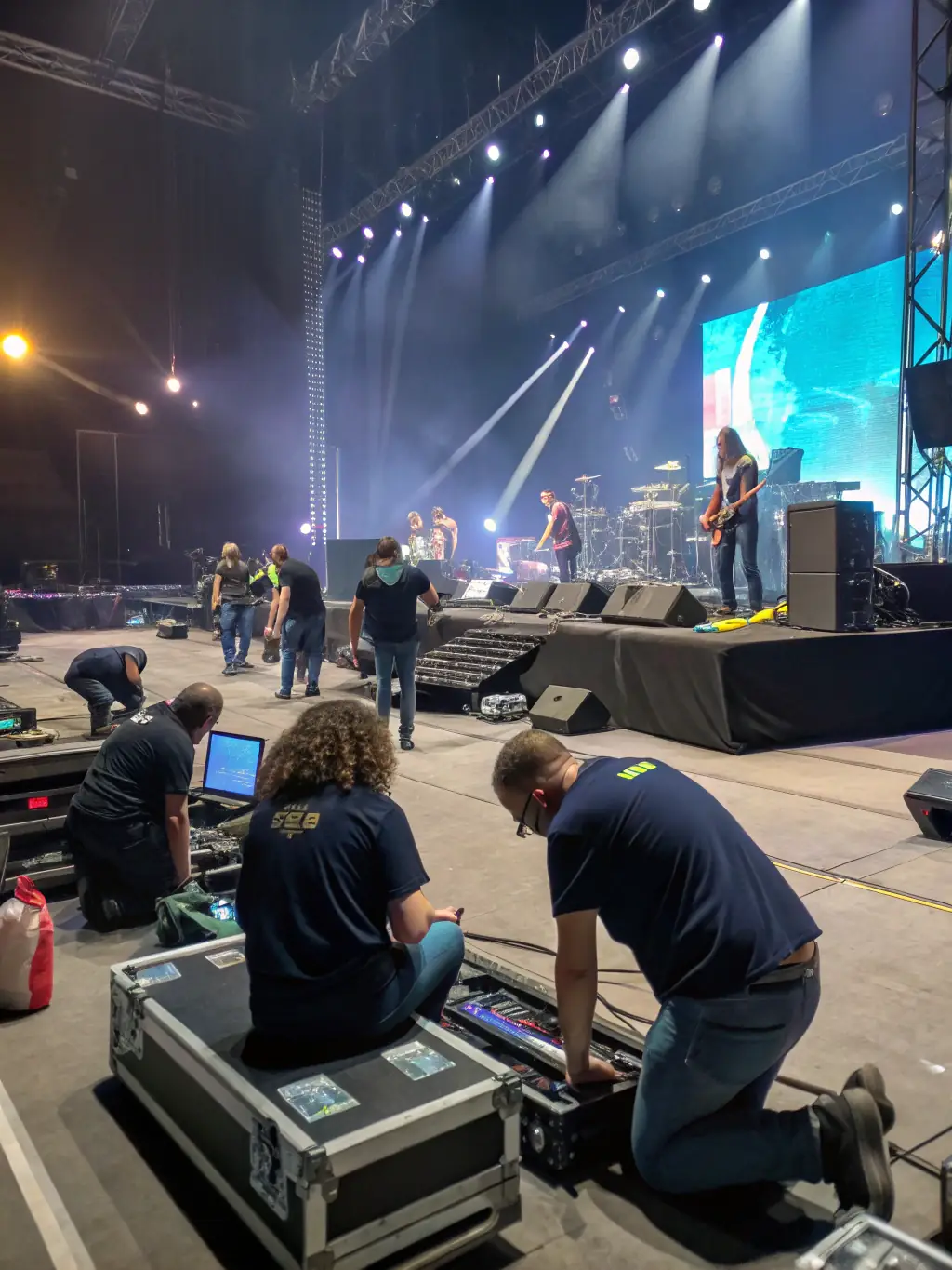 A photo of volunteers setting up the stage for an outdoor concert, highlighting the teamwork and dedication behind the organization's events.